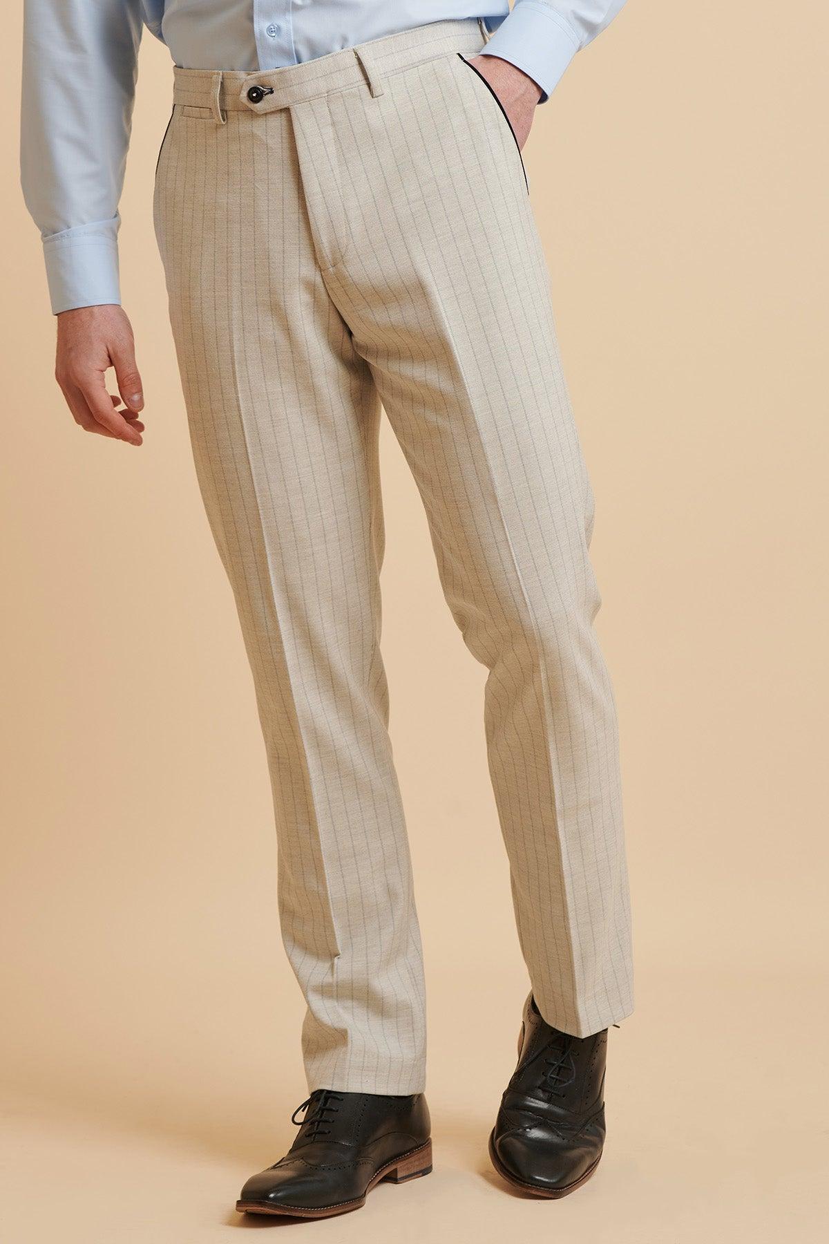 A man models the Marc Darcy Everton Collection's Beto in GRANT Stone Pinstripe Double Breasted Suit against a beige backdrop—cropped at the shoulders to highlight its modern slim fit style.