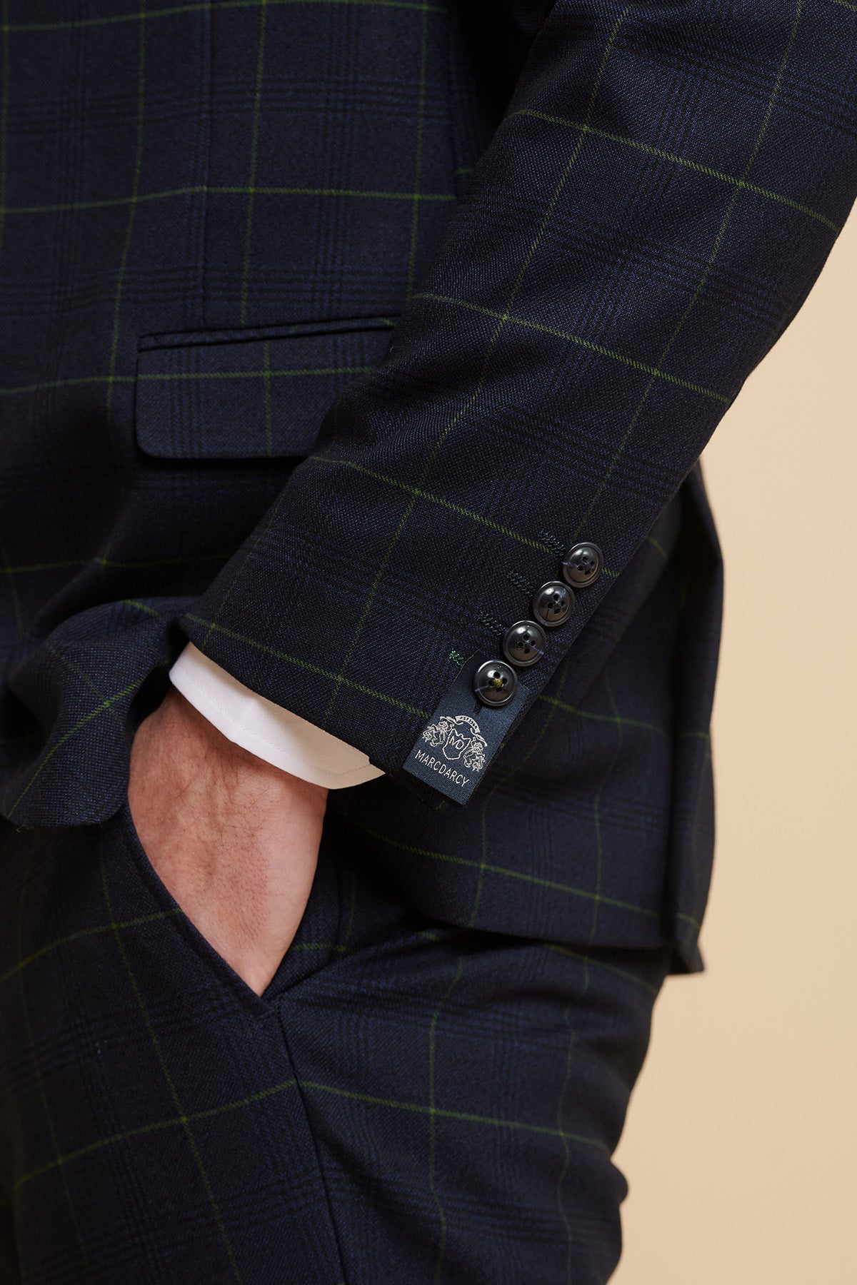 Close-up of a man wearing the Marc Darcy The Everton Collection | Beto In EDINSON Navy Green Check Two Piece Suit, featuring a slim tailored fit, green Prince of Wales check lines, and a four-button cuff with MARC DARCY label.
