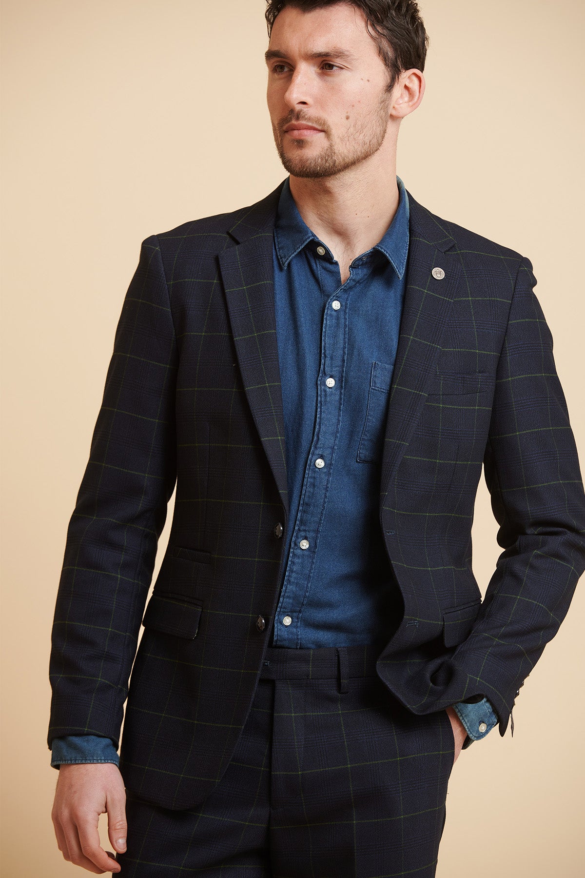 Jordan Pickford wears the Marc Darcy Everton Collection Edinson Navy Green Check Blazer, paired with a blue denim shirt.