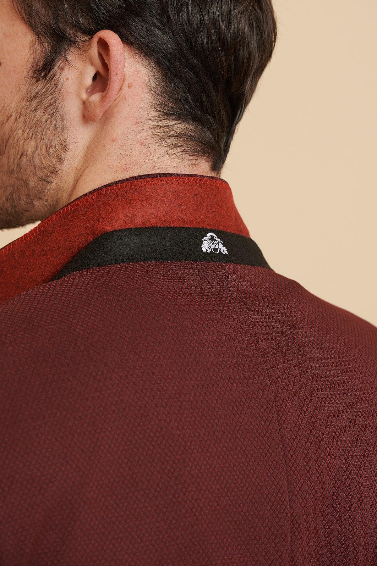 Close-up of a man's neck and collar of the marcdarcy MAX - Wine Two Piece Suit. A small white embroidered crest is visible on the black collar.