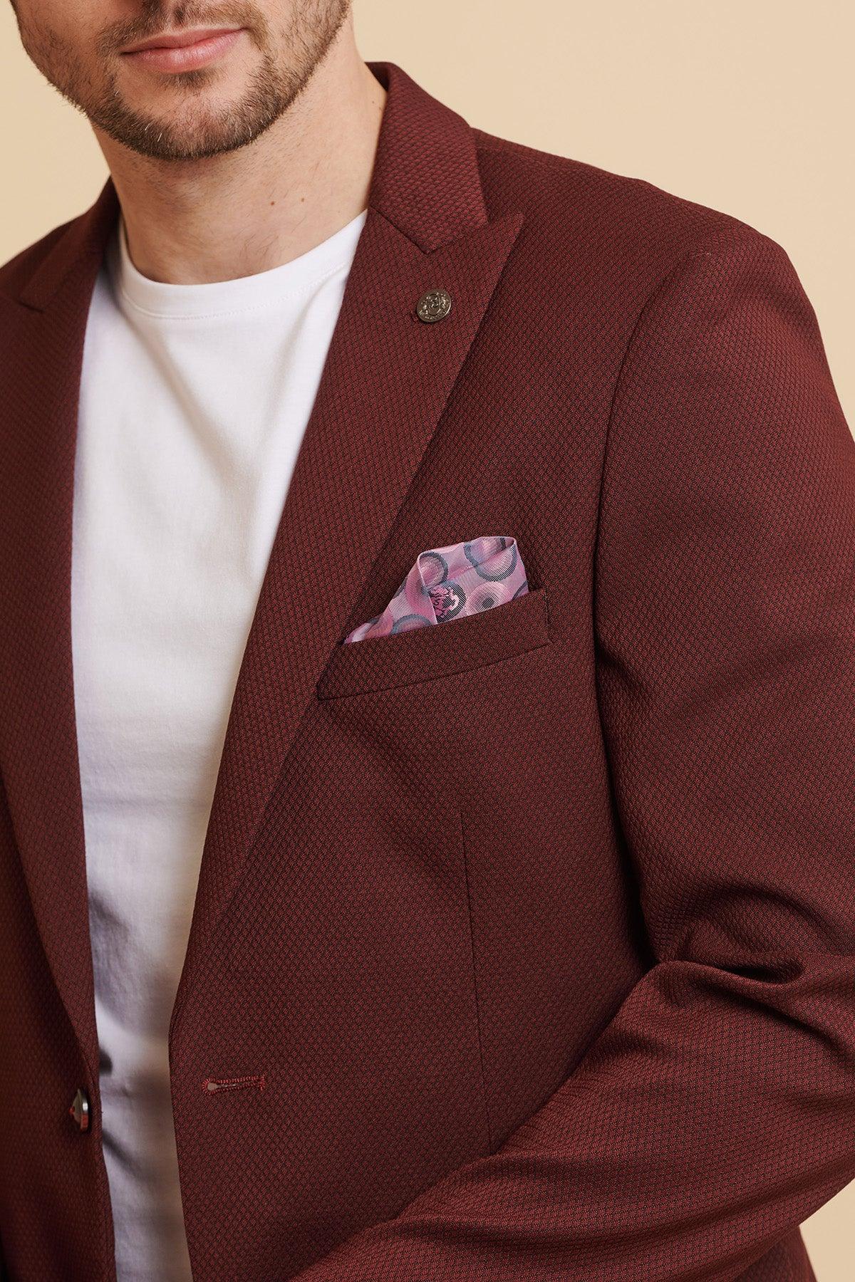 A man wearing the marcdarcy MAX Wine Two Piece Suit over a white t-shirt, accented with a camouflage print pocket square.