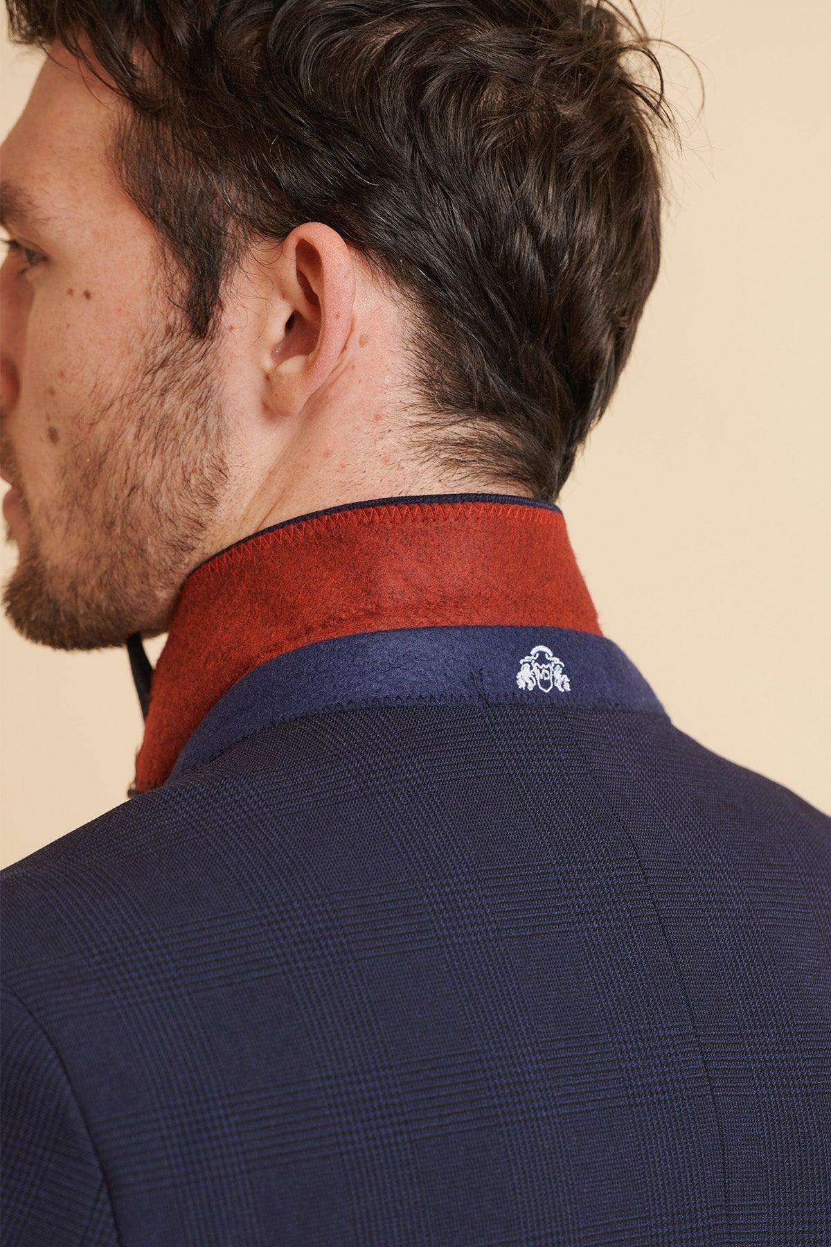 Close-up of a man's neck and shoulder wearing the Marc Darcy Official West Ham United Club Suit | BROMLEY Navy Double Breasted Suit, featuring a red collar, navy band, and white embroidered crest.