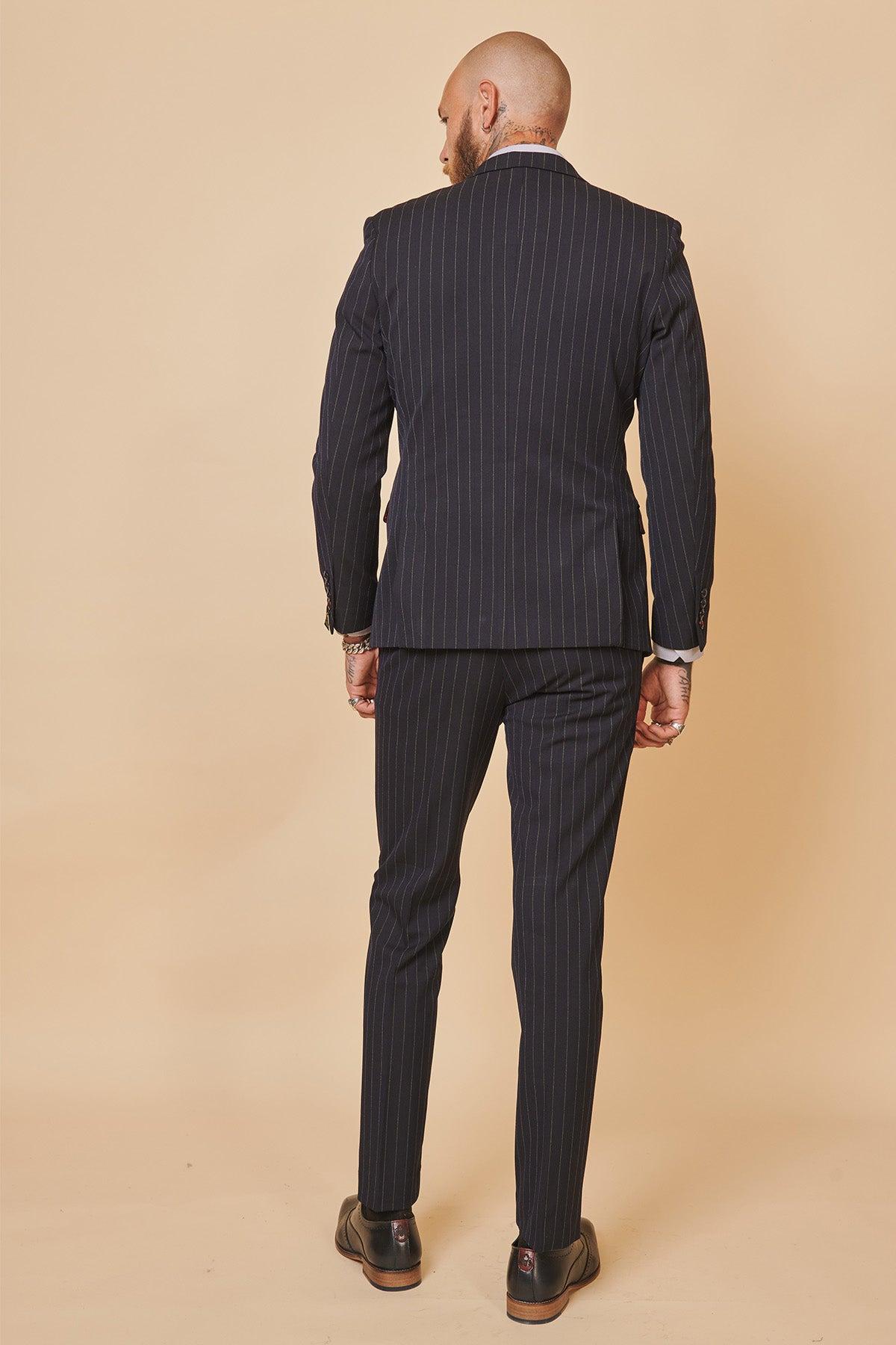 A bald man is seen from behind wearing the Marc Darcy ROCCO Navy Double Breasted Suit from The Cardiff City F.C. Collection, as worn by Ryan Wintle, set against a plain background.