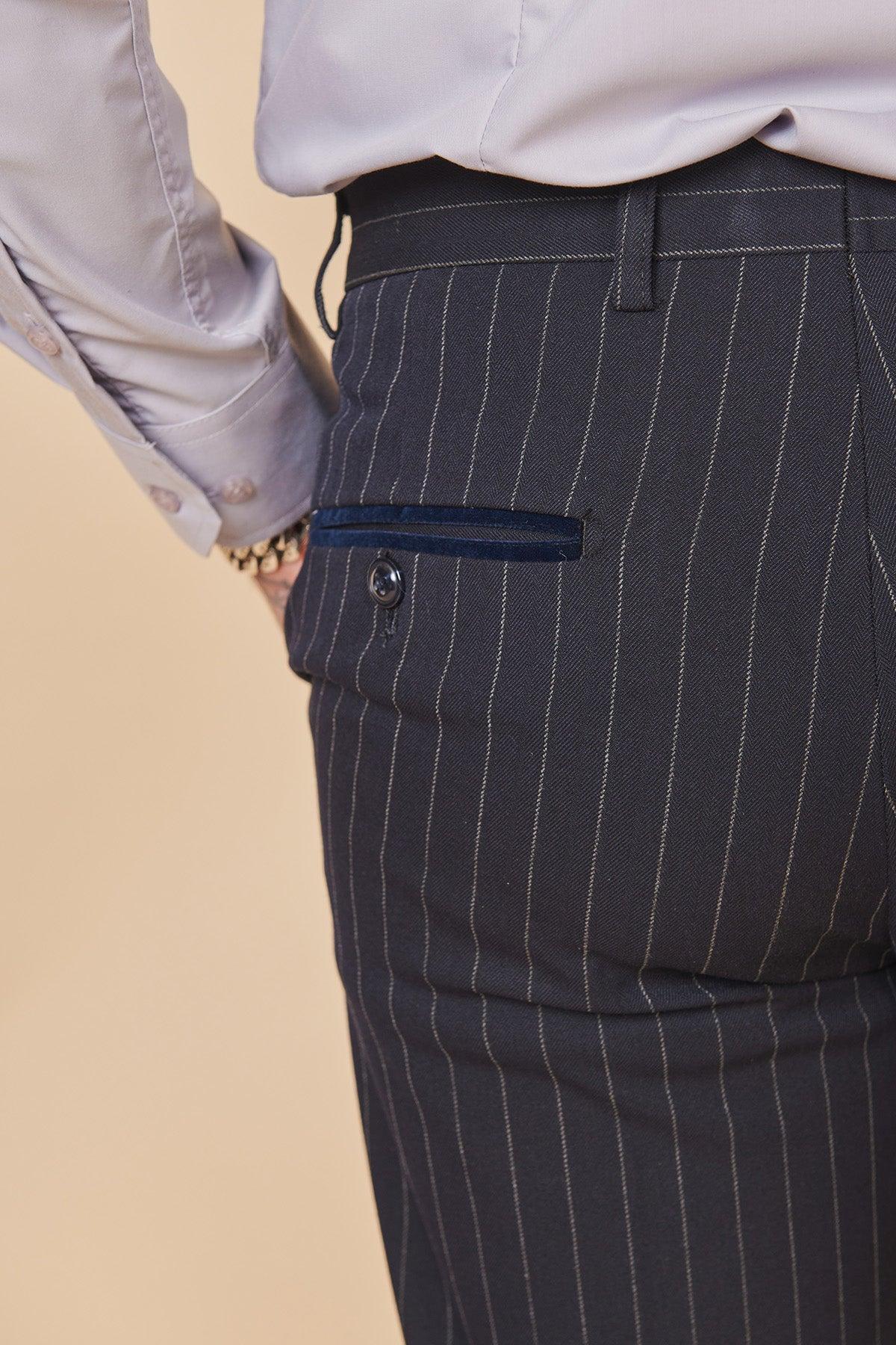 Close-up of Coronation Street's Mason Radcliffe (Luca Toolan) wearing a Marc Darcy ROCCO Navy Pinstripe Double Breasted Two Piece Suit, with a dress shirt, hand on hip, and a bracelet on his wrist.