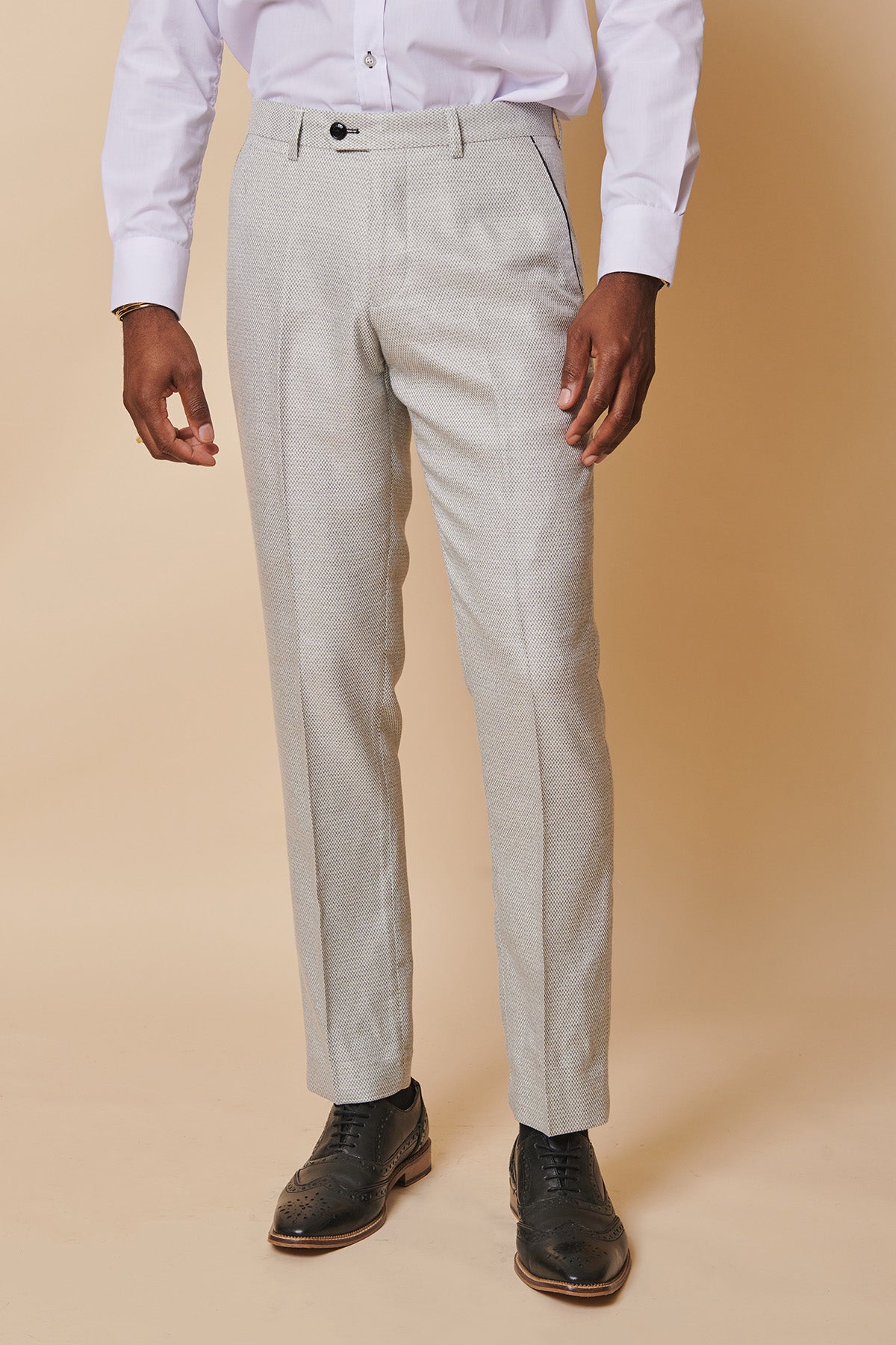 A man models the marcdarcy SPENCER - Stone Tux Lapel Three Piece Suit against a beige background, featuring a tailored fit and elegant style—ideal for formal occasions.