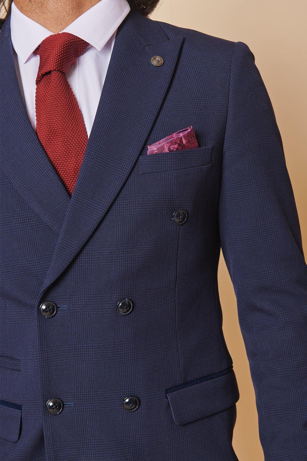Former Sunderland footballer Michael Gray wears the Marc Darcy Bromley Navy Double-Breasted Suit, styled with a white shirt, red textured tie, and purple pocket square. The suit features black buttons and a subtle Prince of Wales check pattern.