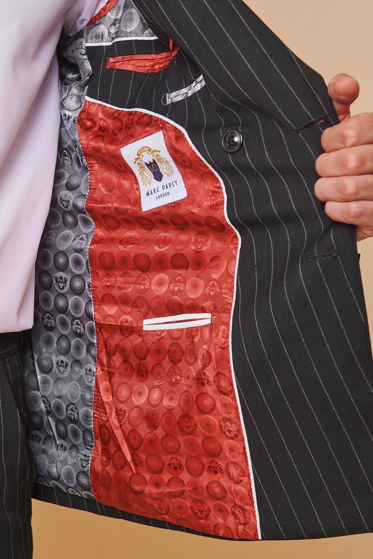 Detail of the lining of Coronation Street's Mason Radcliffe (Luca Toolan) in the Marc Darcy ROCCO Black Pinstripe Double Breasted Two Piece Suit, featuring a red circular pattern and Marc Darcy label.