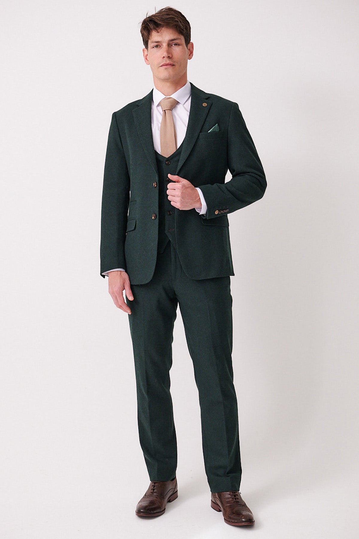 A man wears the marcdarcy ARCHIE Forest Tweed Three Piece Suit, paired with a tan tie and brown dress shoes.