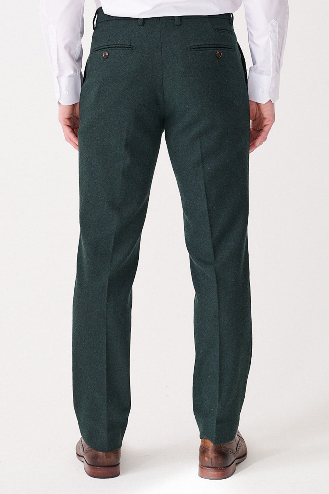 A man is seen from behind wearing marcdarcy ARCHIE - Forest Tweed Trousers, paired with a white shirt and brown dress shoes. The slim fit dark green trousers feature two buttoned back pockets.