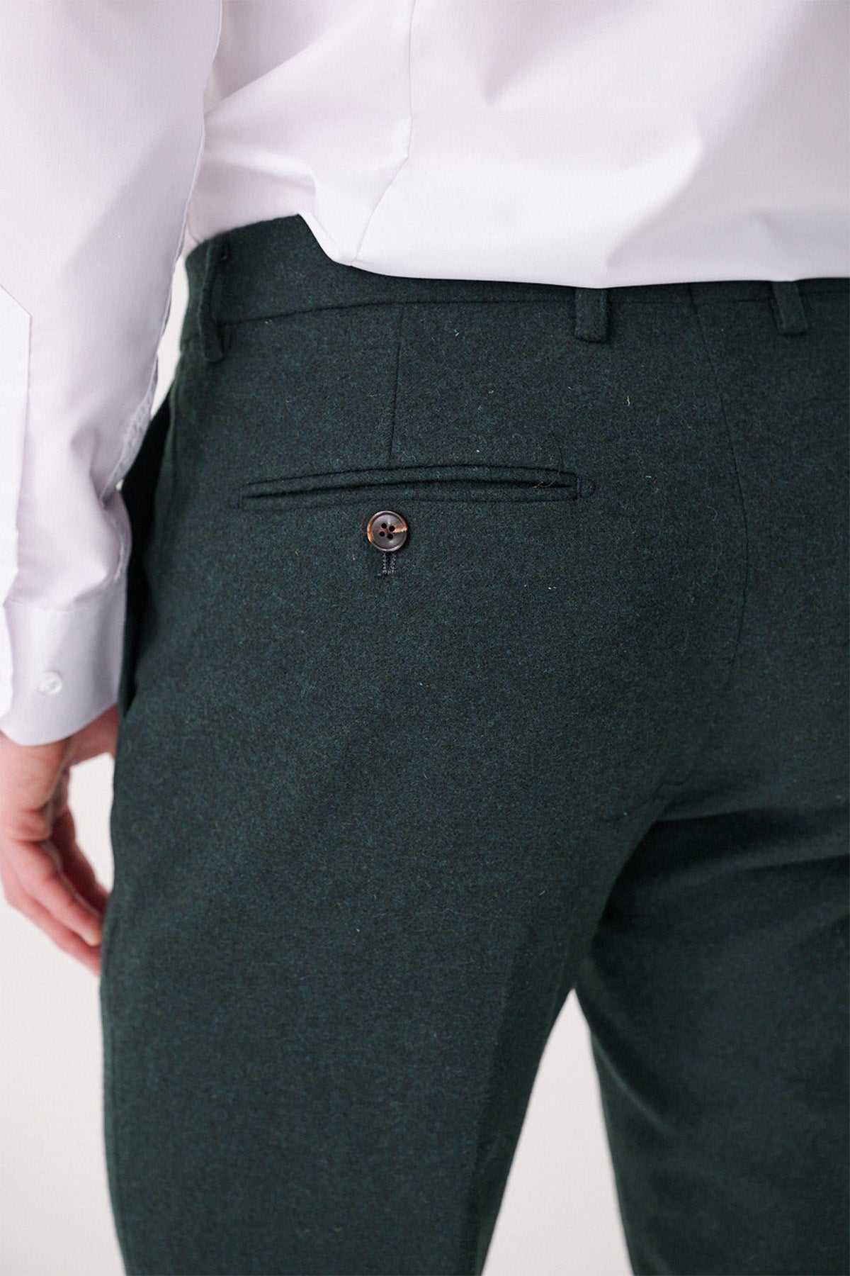 A person, seen from behind in a white dress shirt and marcdarcy ARCHIE - Forest Tweed Trousers, with one hand relaxed at their side and a buttoned pocket visible on the trousers.