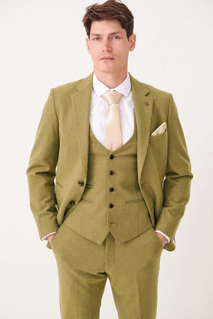 A man wears the marcdarcy ARCHIE - Moss Tweed Blazer three-piece suit in light olive green with a champagne satin tie and pocket square.