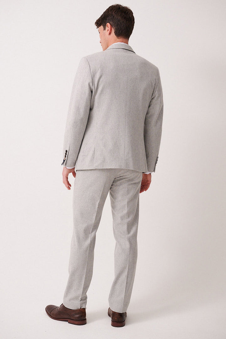 A man faces away from the camera, wearing the marcdarcy ARCHIE Silver Tweed Three Piece Suit with matching trousers and brown dress shoes against a plain white background.