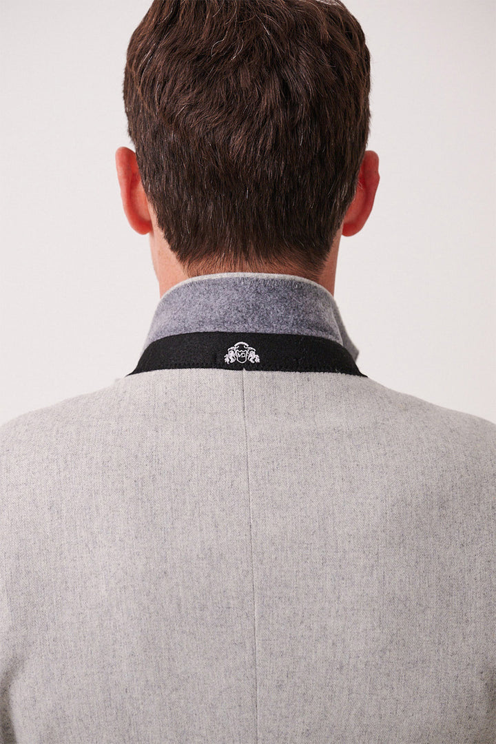A man is shown from behind wearing the marcdarcy ARCHIE Silver Tweed Three Piece Suit. The slim-fit light gray coat features a dark gray collar with a small white embroidered crest on the back, set against a plain, light background.