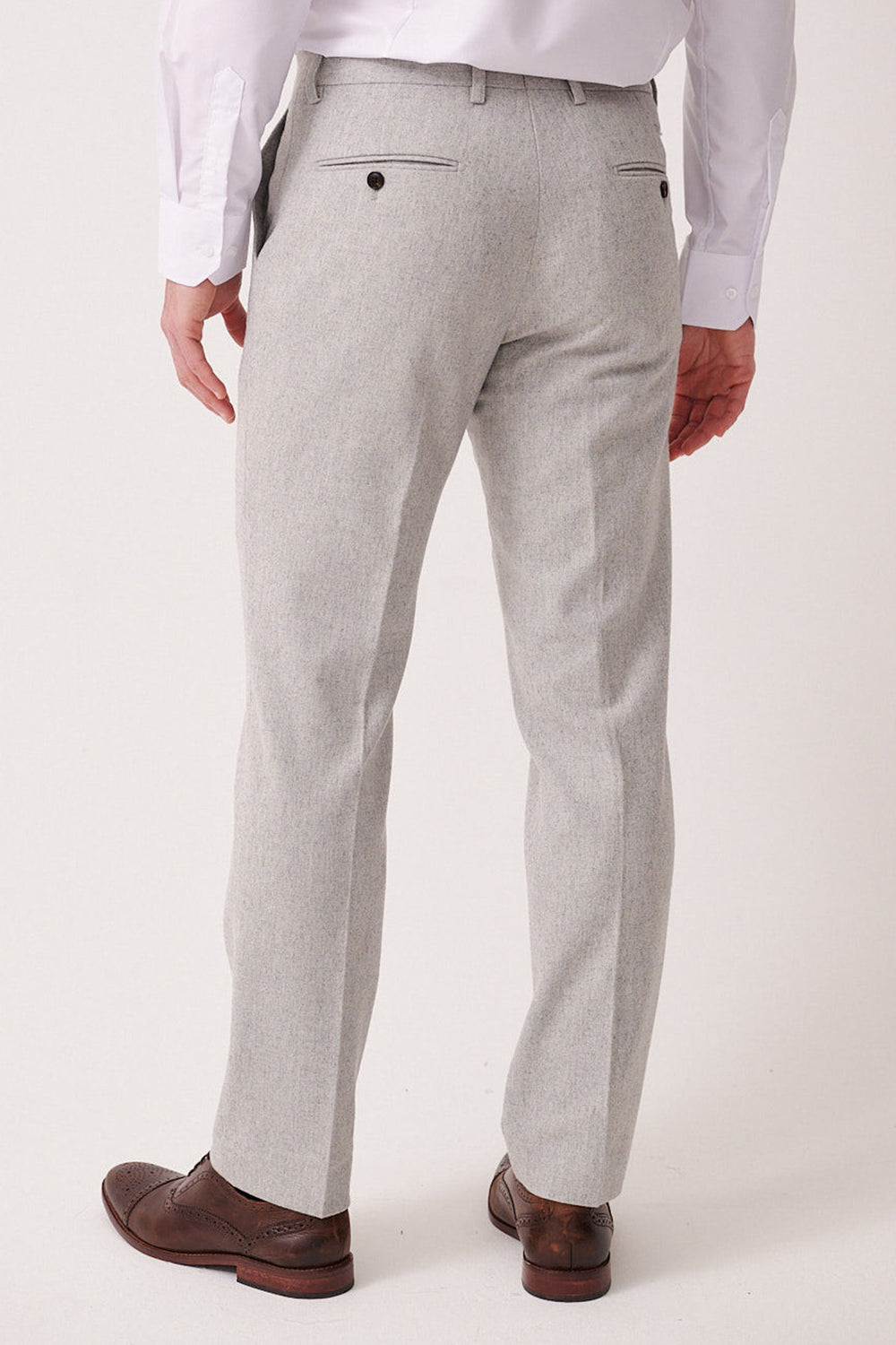 A man is seen from the back wearing marcdarcy ARCHIE Silver Tweed Trousers, a white dress shirt, and brown dress shoes against a plain light background.