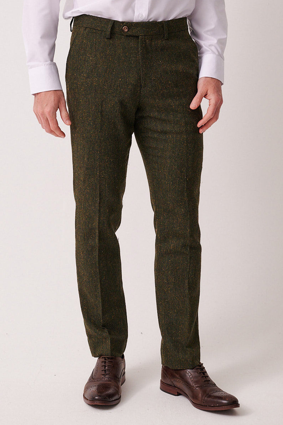 A person models the marcdarcy DEAN - Olive Tweed Three Piece Suit with a white dress shirt and brown leather shoes, standing against a plain light background. The person's head is not visible.