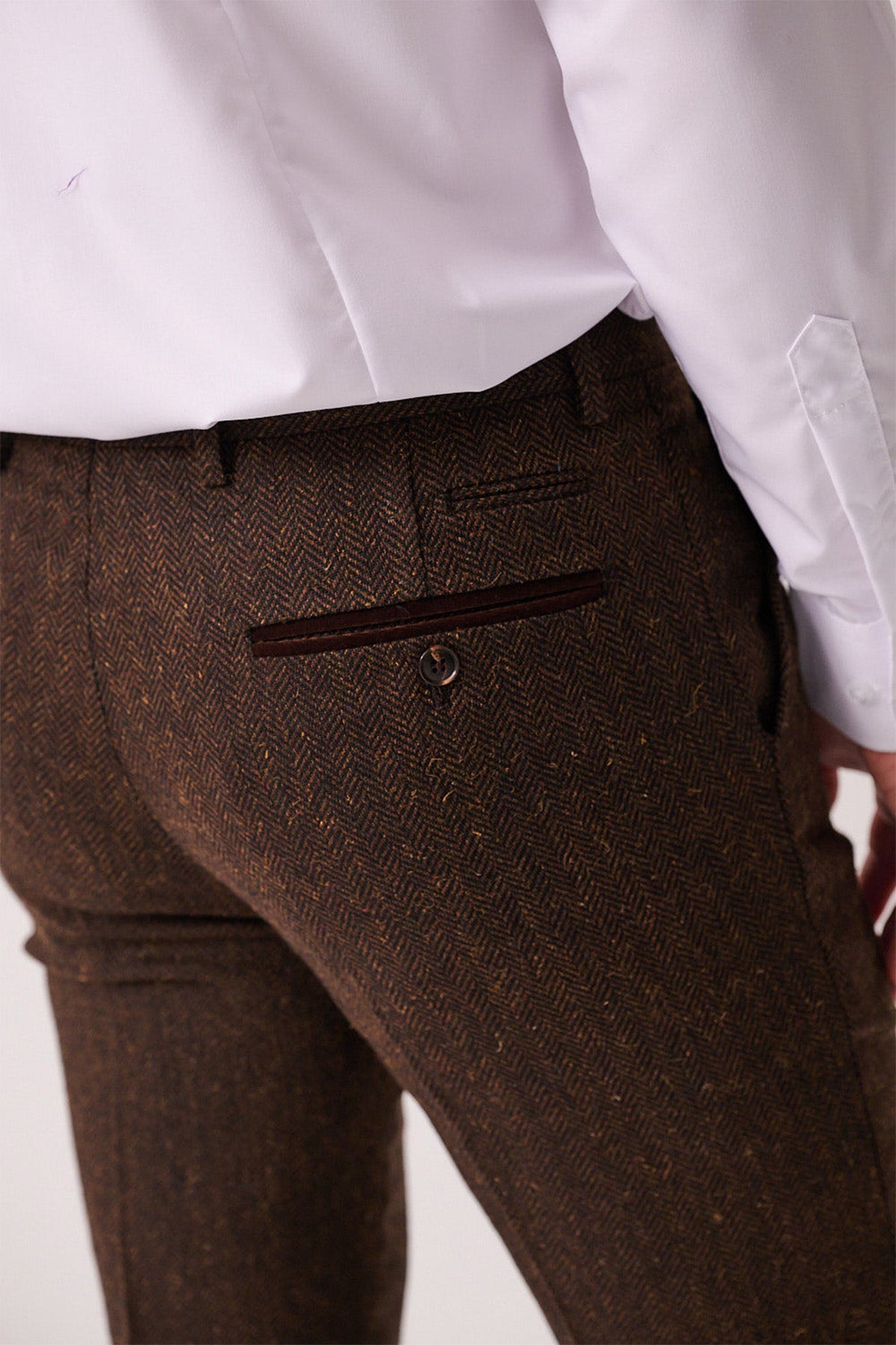 A person shown from the back and waist down wears marcdarcy’s DEAN - Brown Tweed Trousers, highlighting the pants pocket and rich herringbone fabric texture.