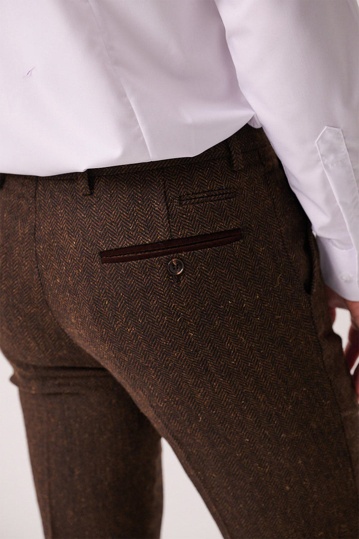 A person shown from the back and waist down wears marcdarcy’s DEAN - Brown Tweed Trousers, highlighting the pants pocket and rich herringbone fabric texture.