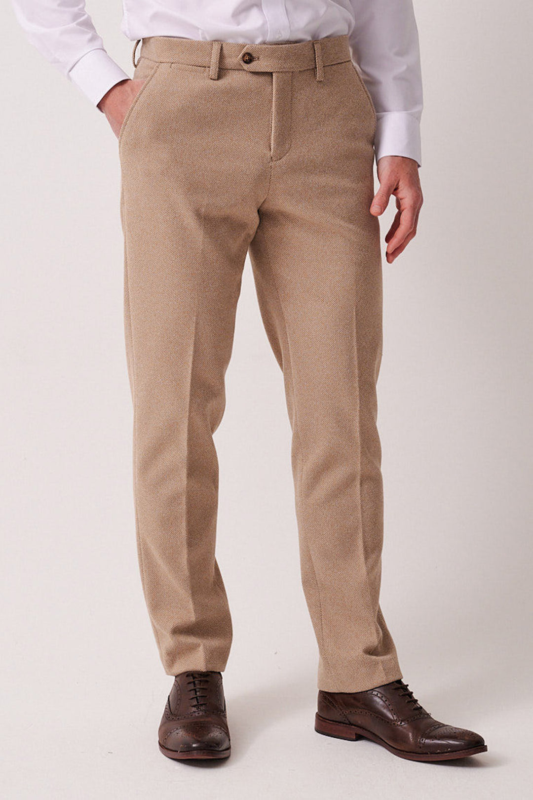 A person models the marcdarcy HAYDEN - Oak Crossweave Three Piece Suit, showcasing tan dress pants and a white shirt with brown shoes against a light background. Only the lower half is visible, highlighting classic style and slim fit.