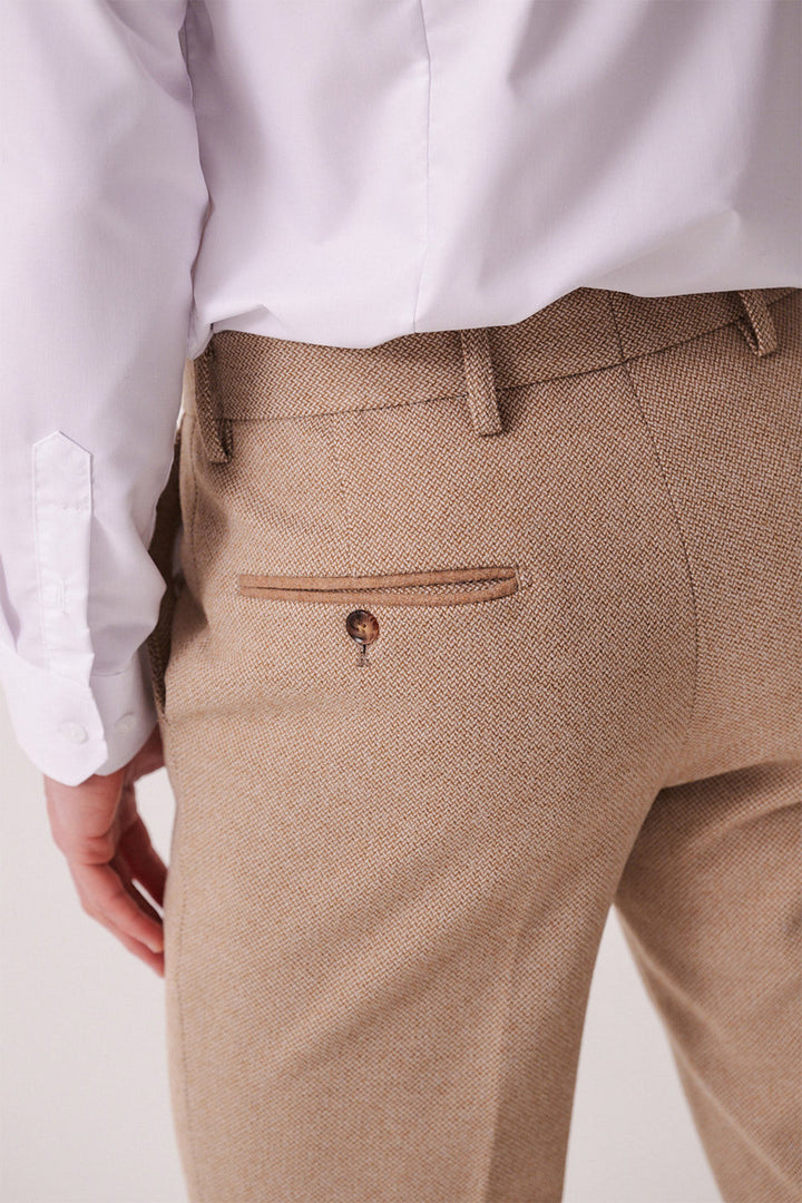 A person is seen from the back wearing a white dress shirt and marcdarcy HAYDEN - Oak Crossweave Trousers, featuring light brown textured fabric and a buttoned back pocket for a formal look.