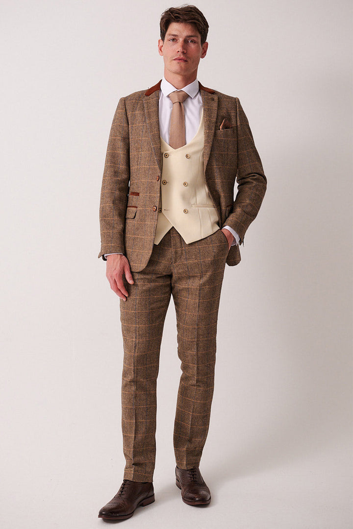A man wears the marcdarcy DX7 Tan Tweed Check Suit with Kelvin Cream Waistcoat, styled with a white shirt, tan tie, and pocket square for a vintage-inspired look.