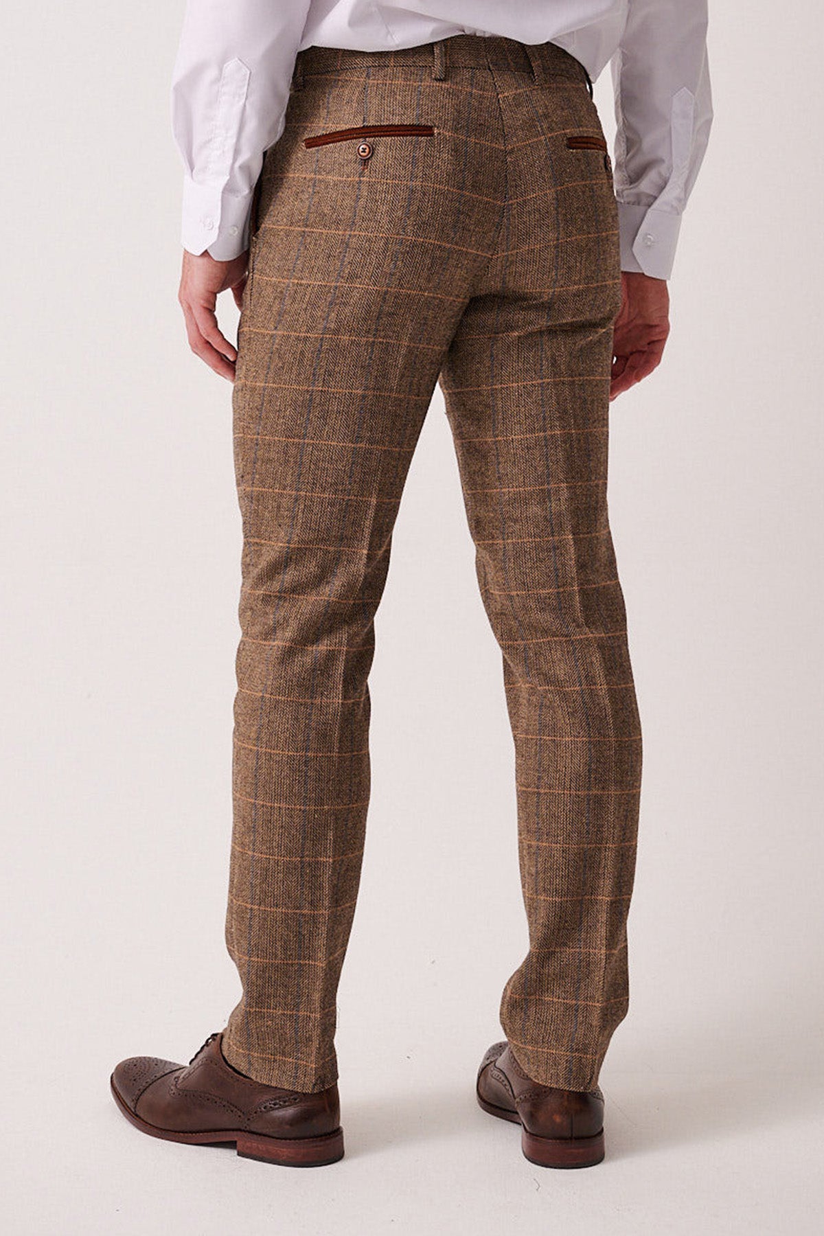 A man wears the marcdarcy DX7 Tan Tweed Check Suit with a Kelvin Cream Waistcoat, paired with a white shirt and brown wingtip shoes for a vintage-inspired look ideal for a rustic country wedding.