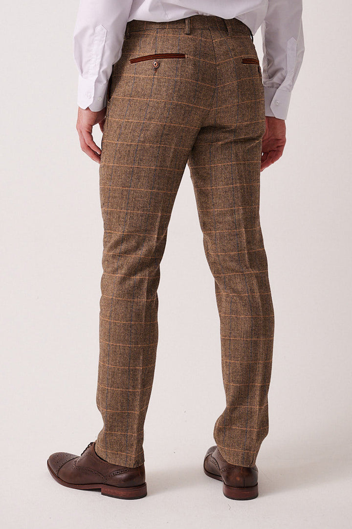 A man wears the marcdarcy DX7 Tan Tweed Check Suit with a Kelvin Cream Waistcoat, paired with a white shirt and brown wingtip shoes for a vintage-inspired look ideal for a rustic country wedding.