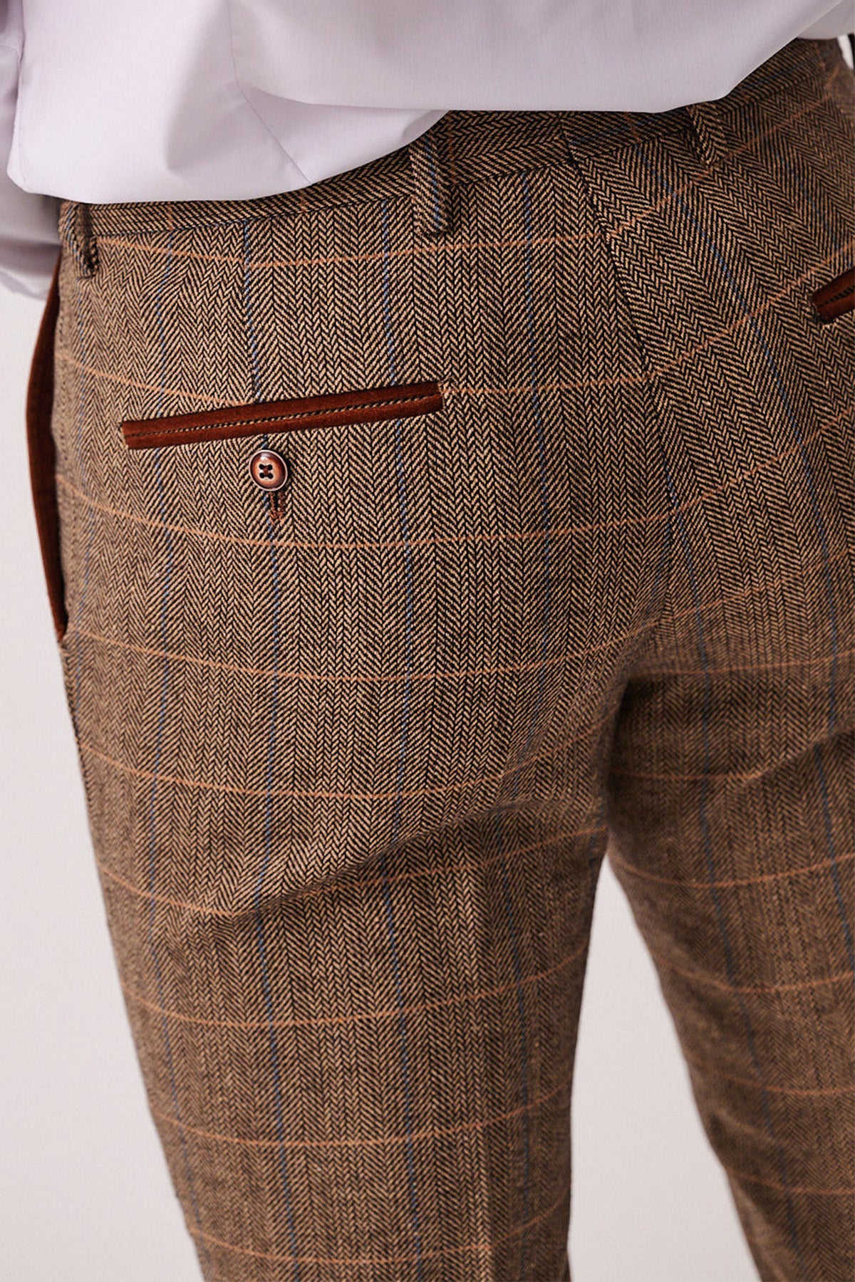 Close-up of the marcdarcy DX7 tan tweed check suit with Kelvin cream waistcoat, showcasing brown herringbone plaid trousers and buttoned pockets—ideal for a vintage-inspired country wedding look.