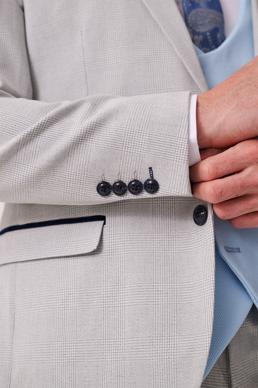 Close-up of the Marc Darcy BROMLEY Stone Check Suit with Kelvin Sky Waistcoat, featuring a sleek fit, dark blue sleeve buttons, and pocket detail—a stylish choice for a men’s three piece suit.