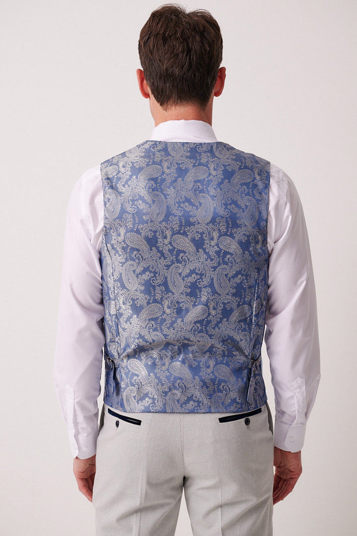 A man facing away wears the Marc Darcy BROMLEY stone check suit pants with the Kelvin Sky paisley waistcoat over a white shirt.