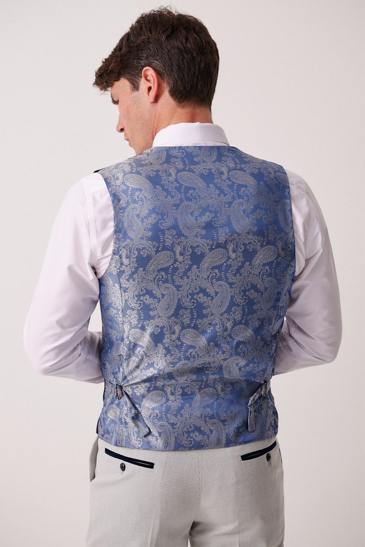 Back view of a man wearing the Marc Darcy BROMLEY Stone Check Suit trousers and Kelvin Navy Waistcoat.