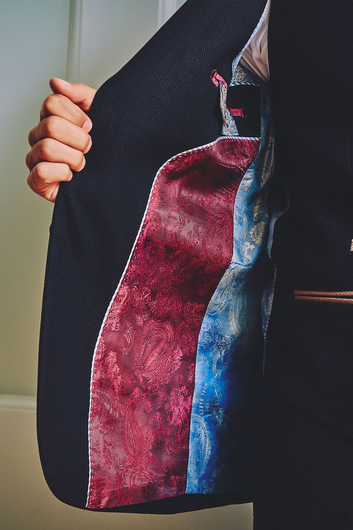 Someone opens the marcdarcy MD7 - Navy Blue Three Piece Suit, displaying its slim fit style and showcasing a vibrant red and blue paisley-patterned lining.