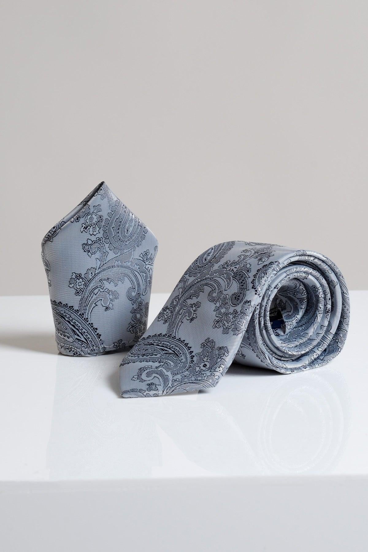 The MD PAISLEY - Grey Paisley Tie and Pocket Square Set by Accessory is shown on a glossy white surface with a plain light gray background, ideal for elevating your formal style with modern accessories.