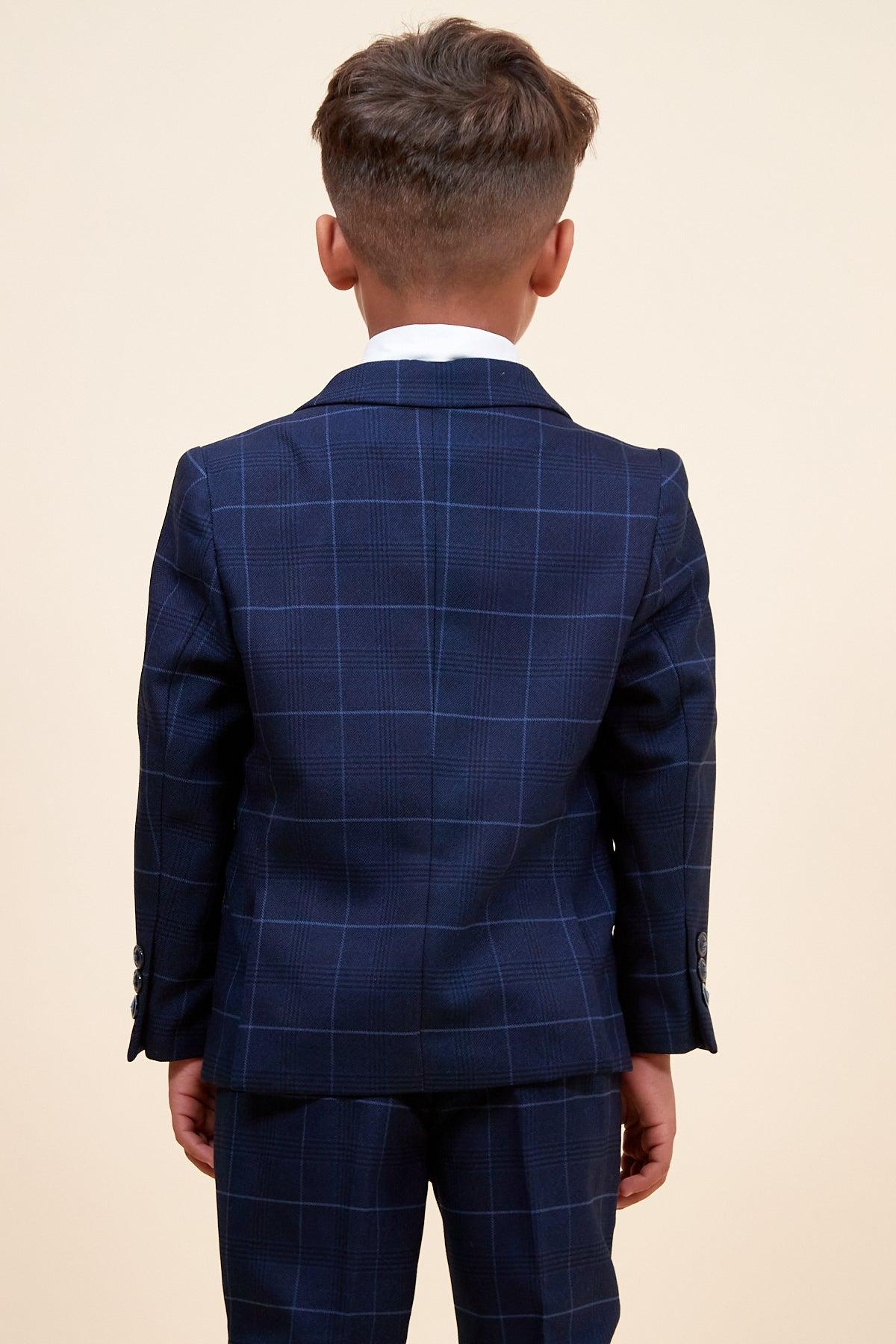Back view of a young boy wearing the EDINSON Children's Navy Sky Check Print Three Piece Suit by Marc Darcy, featuring a plaid jacket and matching pants.