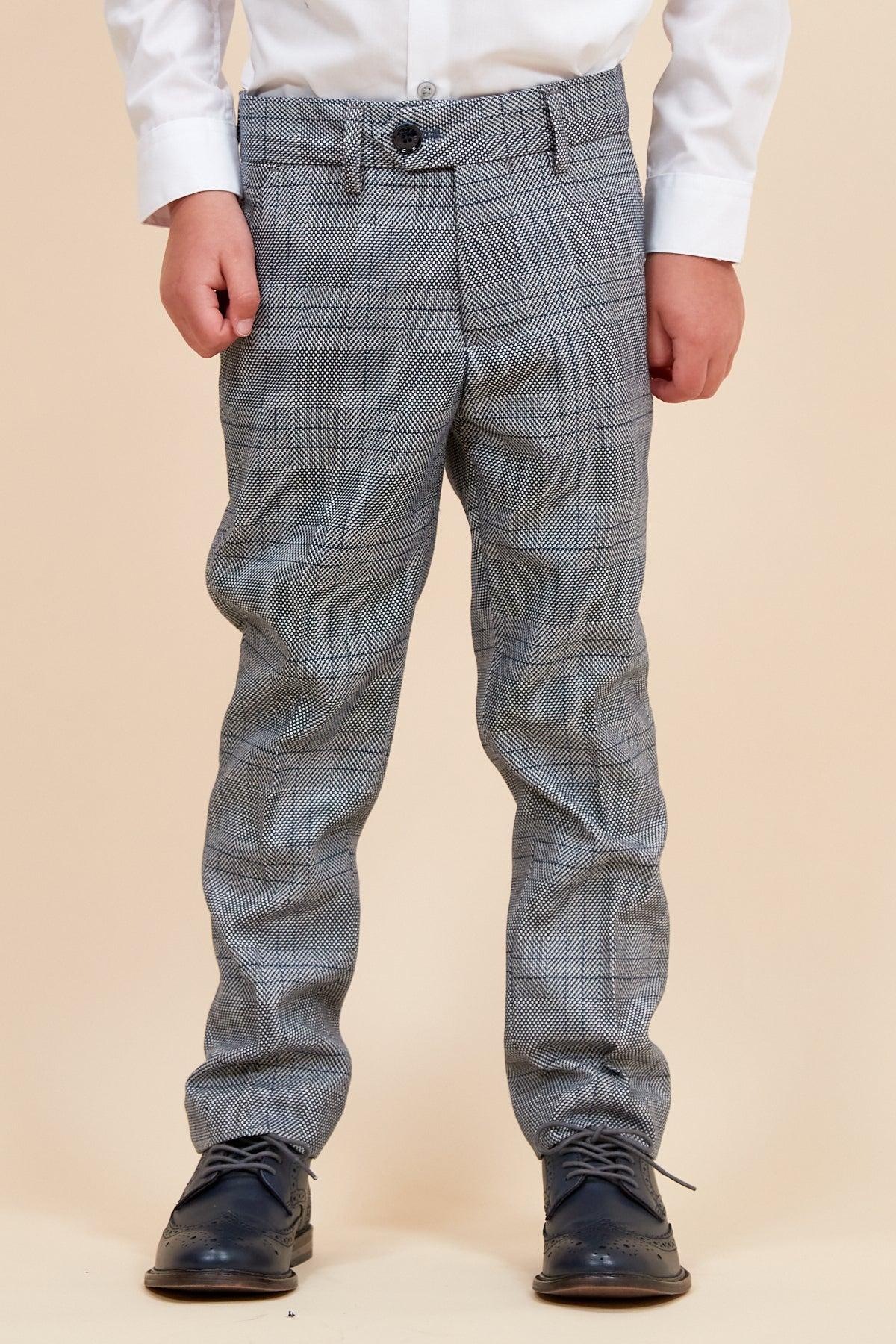 A young child wears the marcdarcy JERRY Childrens Grey Check Three Piece Suit with an adjustable waistband, white button-up shirt, and black dress shoes against a plain beige background. The childs face is not visible.