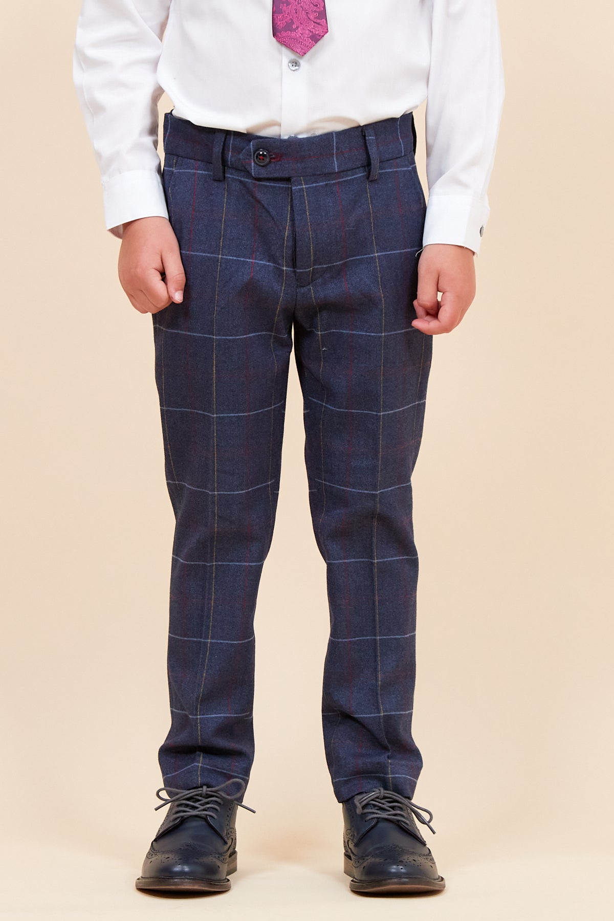 A child models the DRAKE Children's Navy Check Three Piece Suit by marcdarcy, featuring a white shirt and pink tie—perfect for a stylish, modern pageboy look.