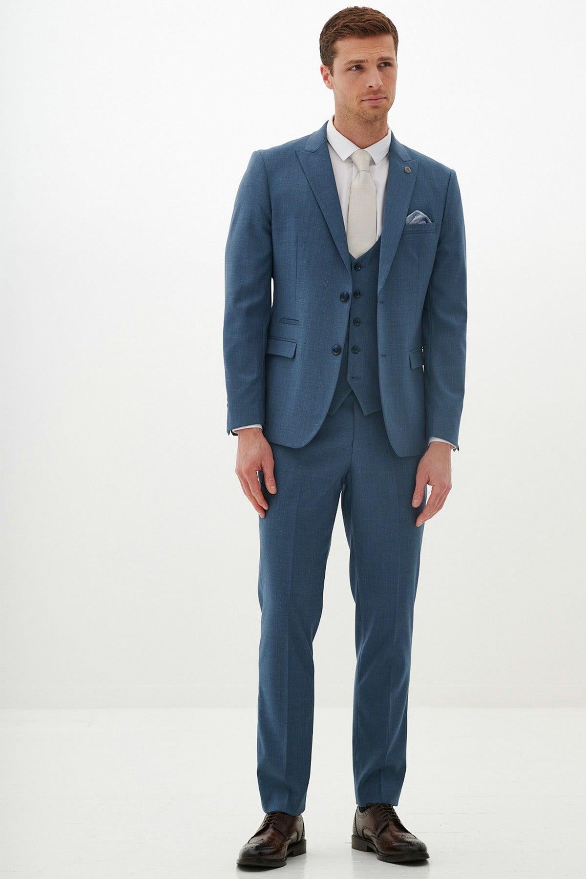 A man wears the Marc Darcy FINLEY Teal Blue Three Piece Suit with a white shirt and beige tie, standing against a white background.