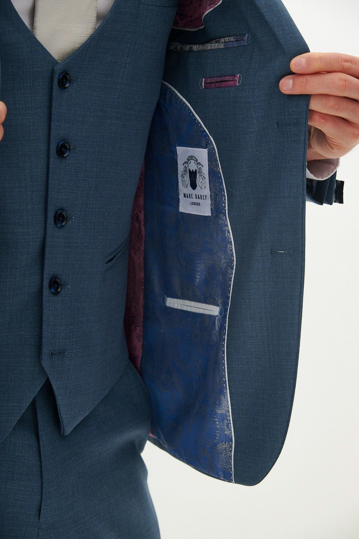 A tailored fit FINLEY teal blue three piece suit jacket by Marc Darcy is open, showing its patterned lining and Marc Darcy label.