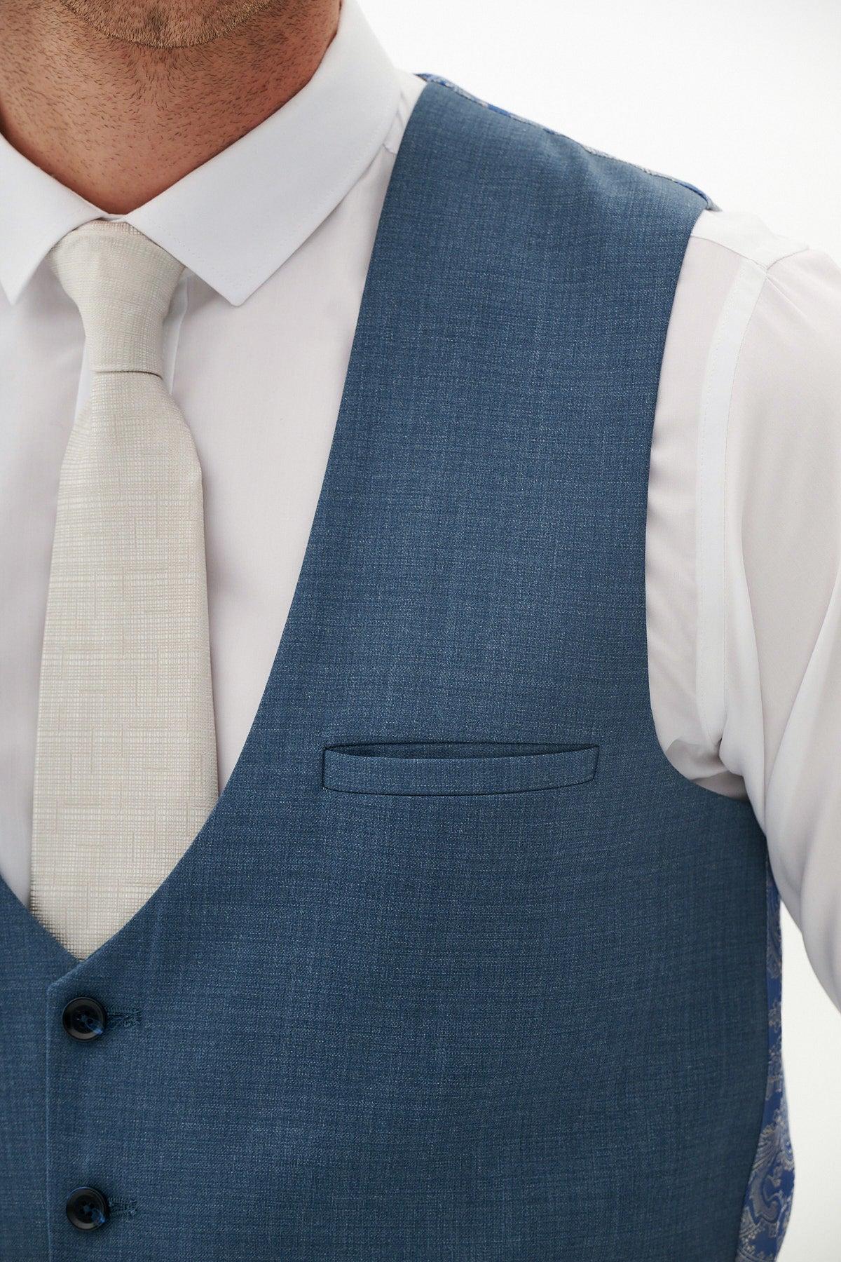 A man wears the Marc Darcy FINLEY teal blue single breasted waistcoat, paired with a white shirt and light beige tie—an elegant summer formalwear look, shown from shoulders to mid-torso.