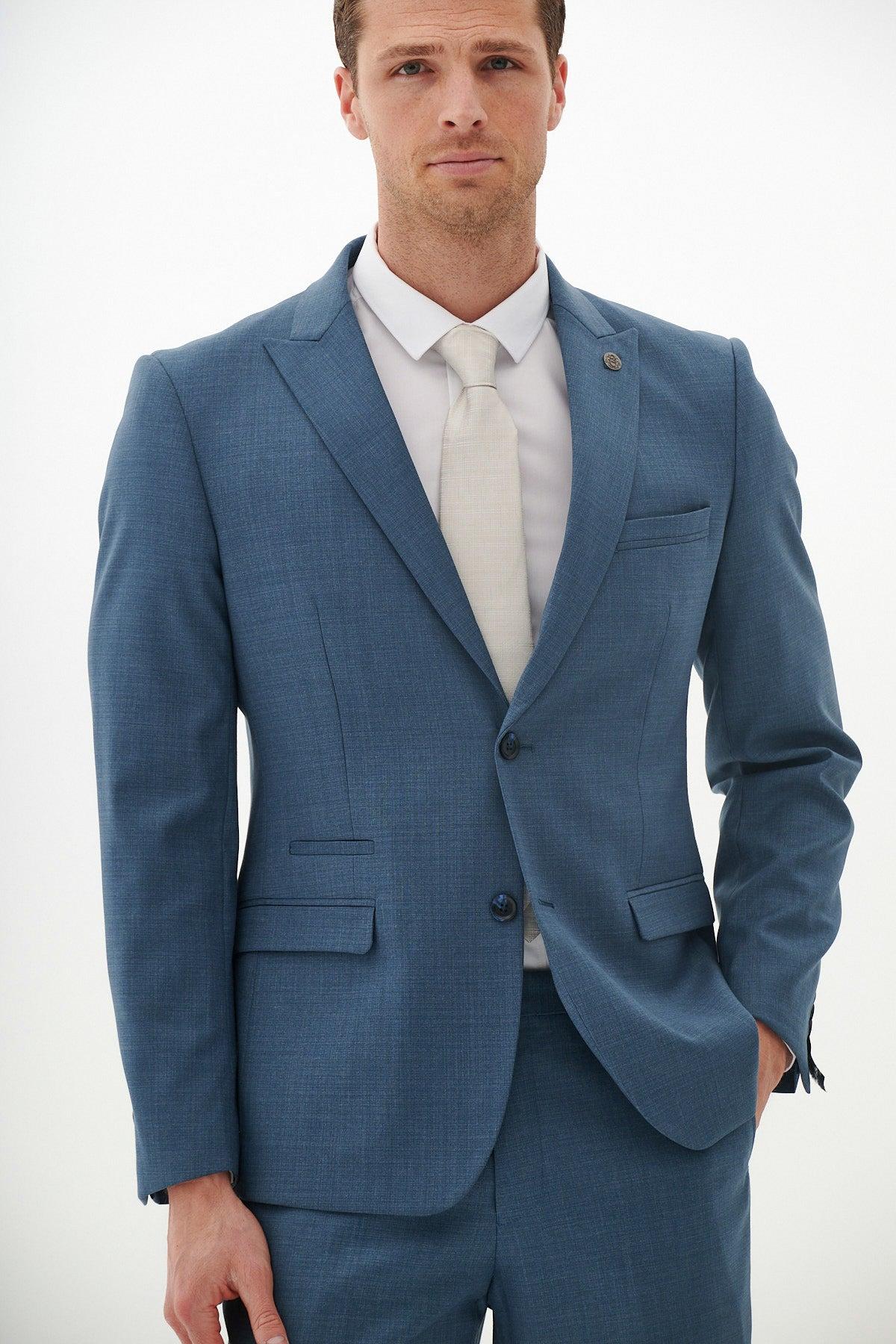 Man wearing a Marc Darcy FINLEY Teal Blue Tailored Blazer with peak lapels, paired with a white dress shirt and cream tie, against a white background.