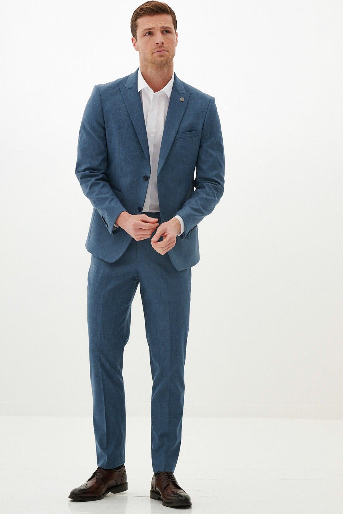 A man in the Marc Darcy FINLEY - Teal Blue Two Piece Suit stands against a white background, wearing a white shirt and brown shoes—an ideal summer wedding look.