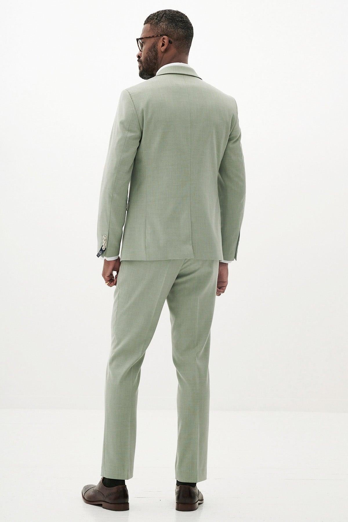 Back view of a man wearing the Marc Darcy FINLEY - Moss Green Tailored Blazer, paired with a white shirt, glasses, and brown dress shoes.