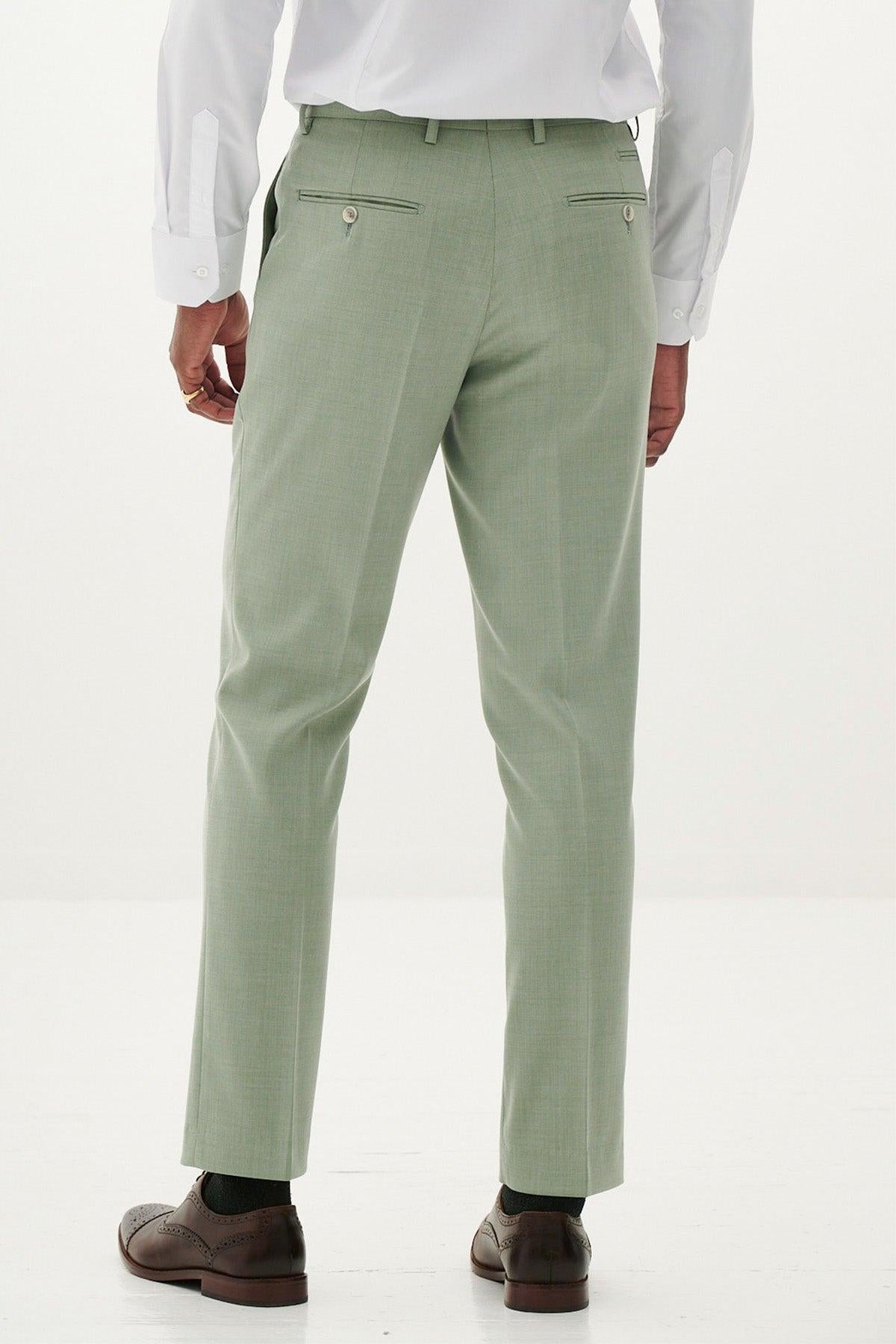 A man, seen from the back, wears the Marc Darcy FINLEY Moss Green Two Piece Suit with a crisp white shirt, brown dress shoes, and a gold ring—an ideal choice for a stylish summer wedding look.
