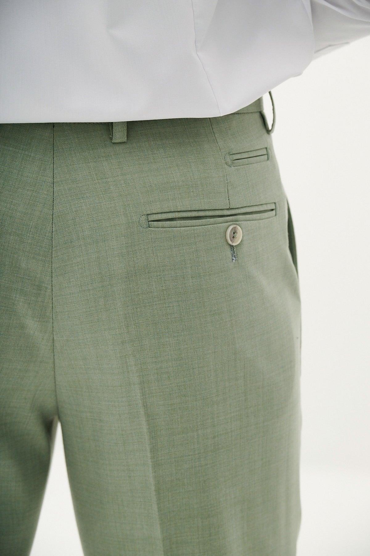 Close-up of a person wearing the Marc Darcy FINLEY - Moss Green Two Piece Suit, featuring lightweight fabric dress pants with a single back pocket and beige button, paired with a tucked-in white shirt—ideal for summer weddings.