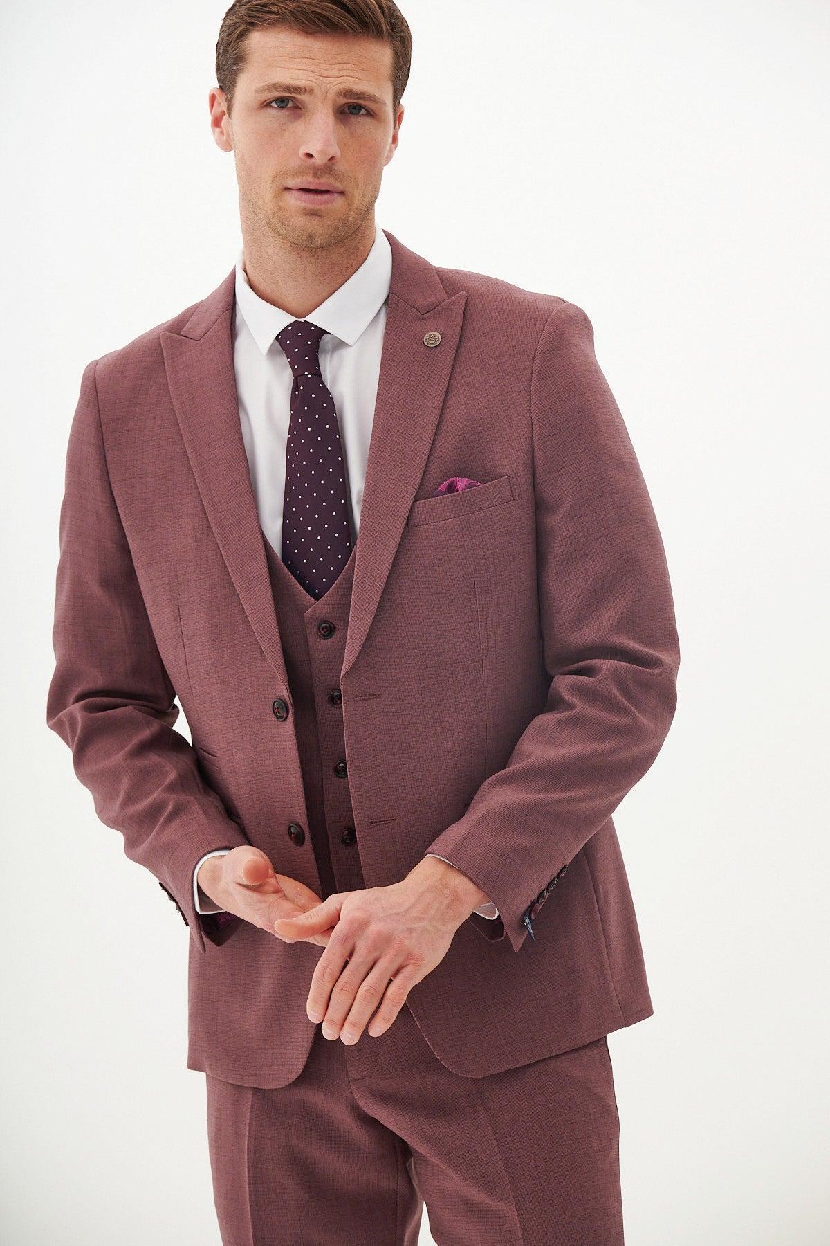 A man models the Marc Darcy MONTY Mauve Tailored Blazer as part of a three-piece suit, paired with a white shirt and dark purple polka dot tie, standing against a plain white background with hands clasped.