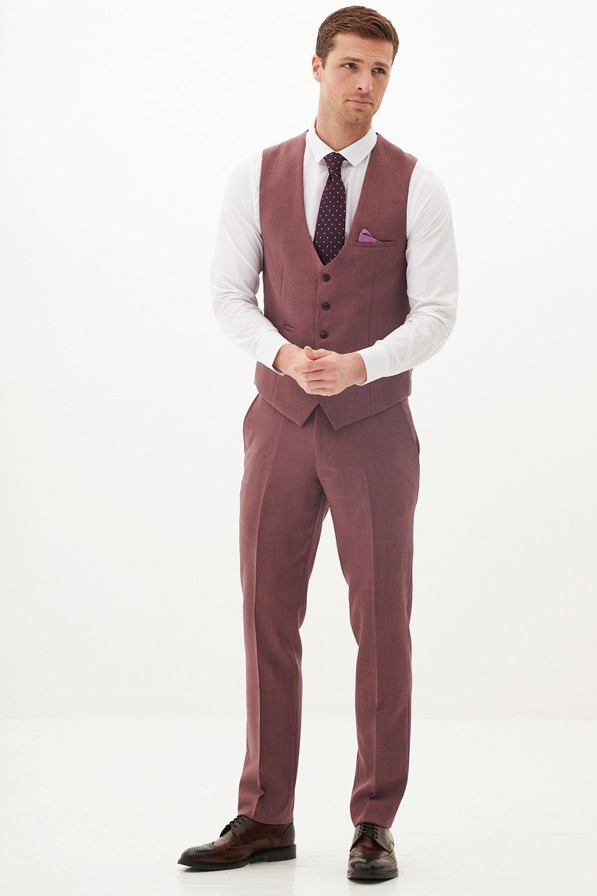 A man with short brown hair and a neutral expression wears the Marc Darcy MONTY - Mauve Three Piece Suit, styled with a white shirt, dark purple tie, matching pocket square, and brown dress shoes—ideal for summer weddings.