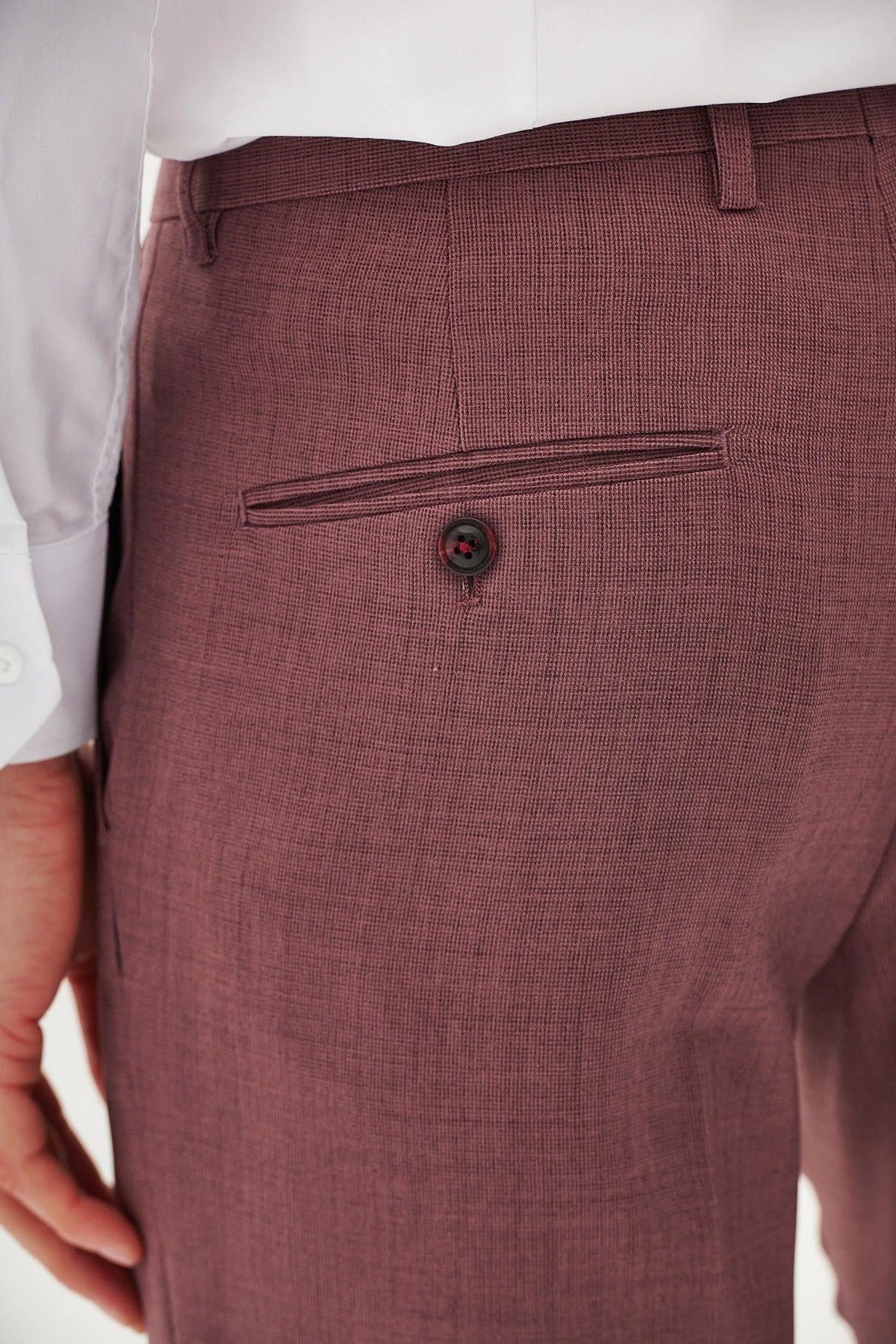 A close-up of a person wearing Marc Darcy's MONTY mauve textured trousers from a three piece suit, featuring a single back pocket and dark button.