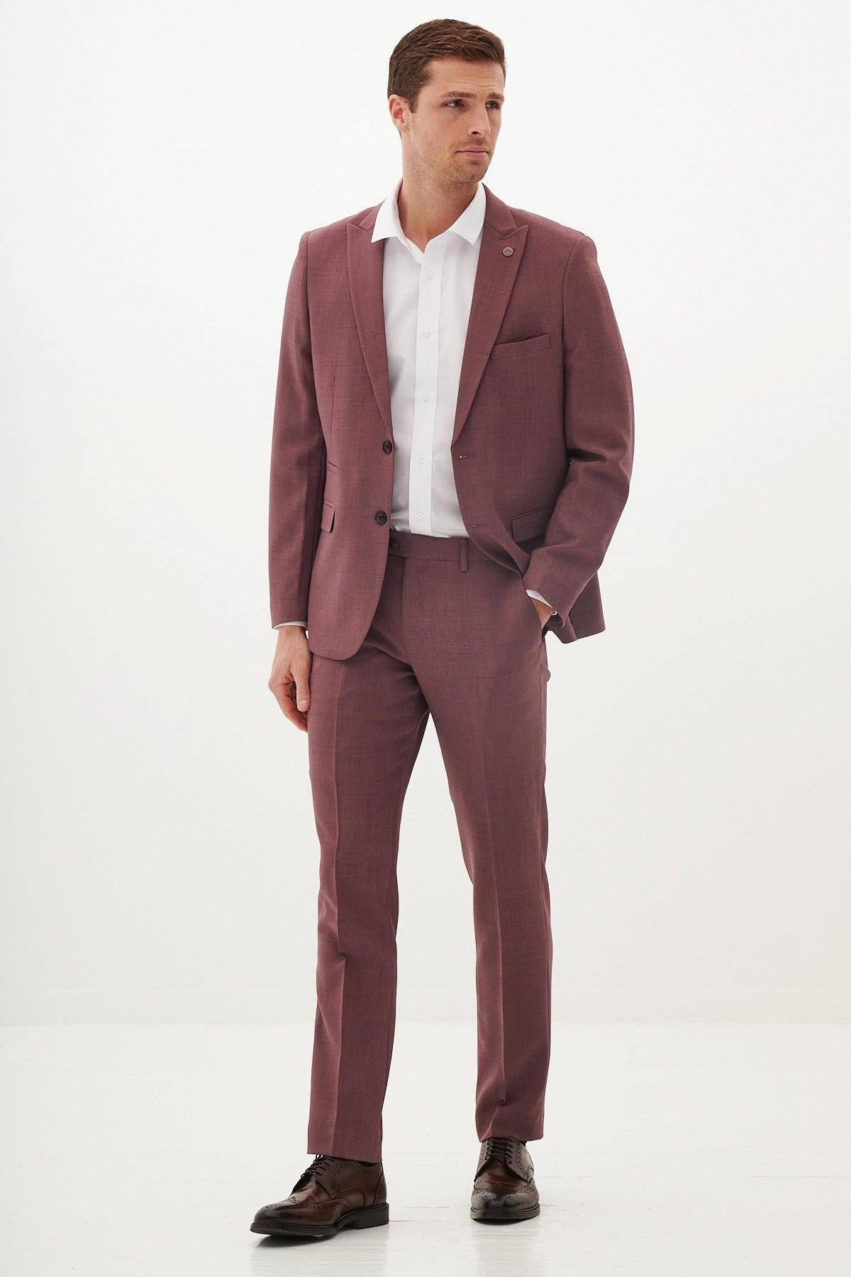 A man in the Marc Darcy MONTY mauve two piece suit with a white shirt and brown shoes stands with his hand in his pocket against a white background—ideal as a summer wedding suit.