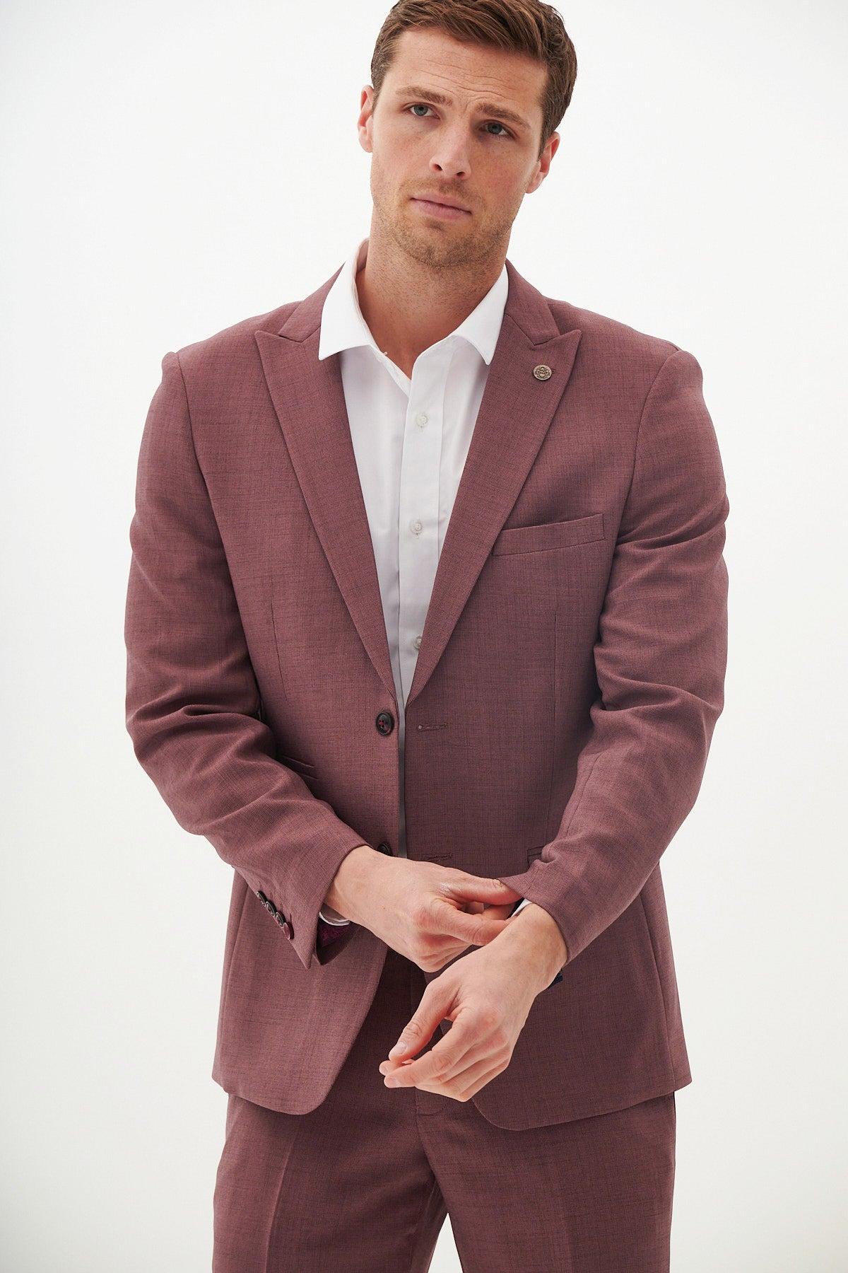 A man in the Marc Darcy MONTY Mauve Two Piece Suit and a white shirt adjusts his cuff against a white background.