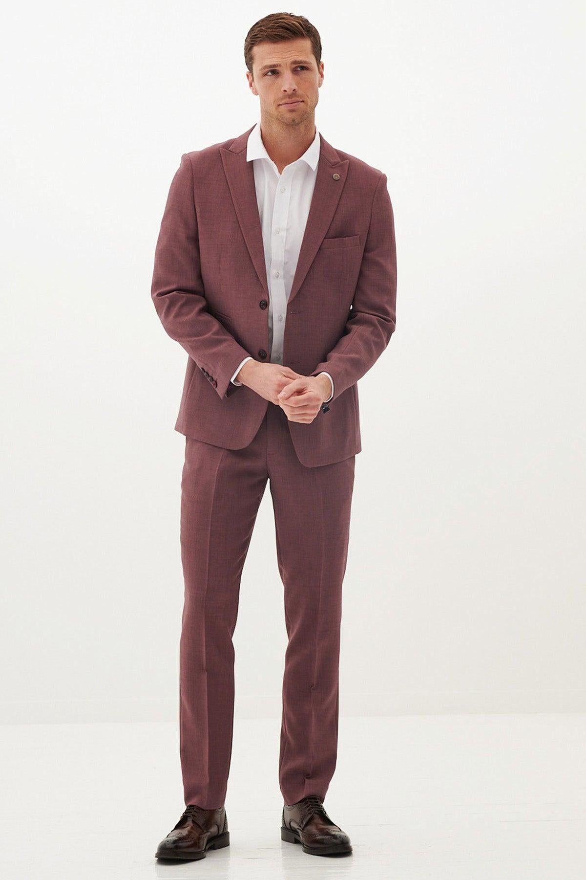 A man wears the Marc Darcy MONTY Mauve Two Piece Suit with a white shirt and dark brown shoes, standing against a plain white background—an ideal summer wedding or formalwear choice. He looks ahead neutrally with hands clasped.