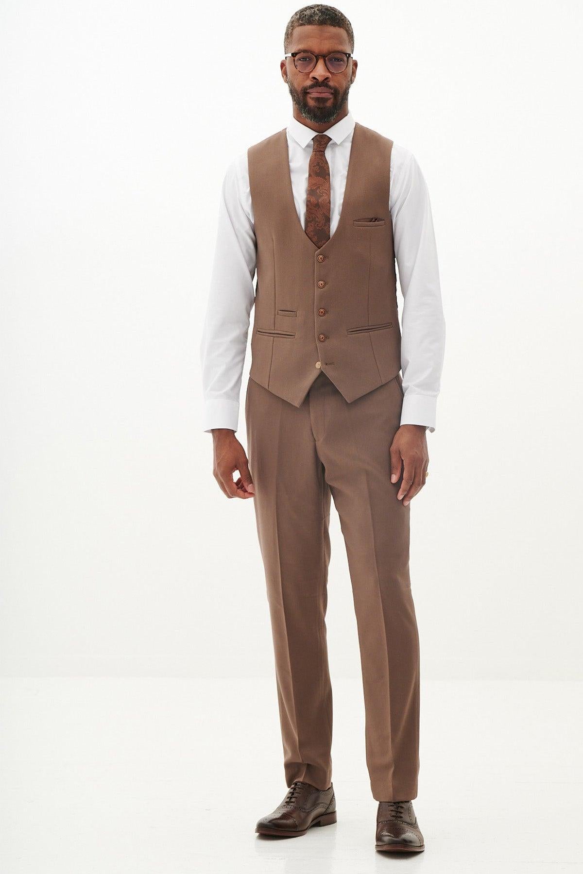 Man in a marcdarcy HM5 tan single breasted waistcoat, brown three-piece suit, white shirt, and patterned tie with subtle paisley lining.